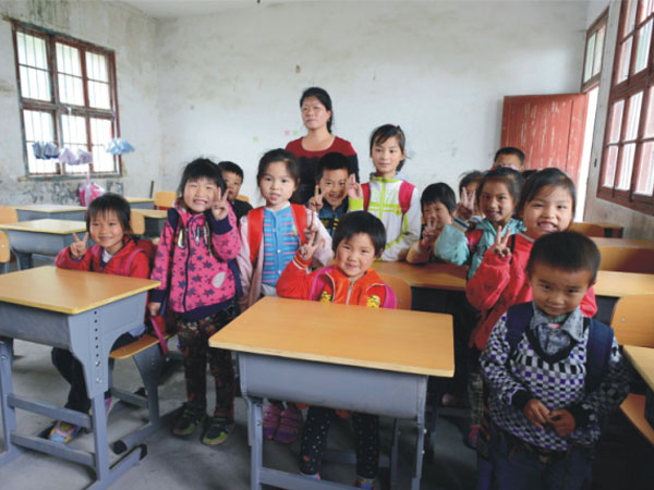 公司為一山村小學捐贈一批課桌椅，孩子們高興地和老師一起合影